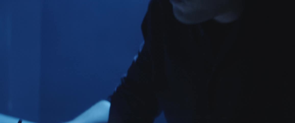 Man drawing a design with pen and paper on a dimly lit office