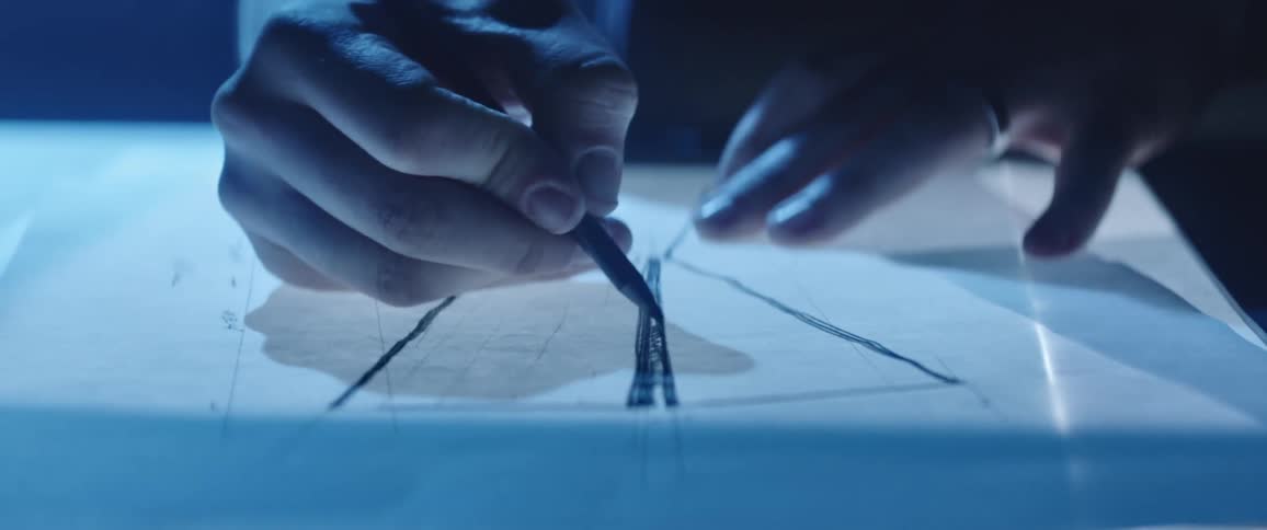 Designer drawing with a pencil on paper over a desk