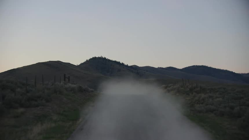 Dust is kicked up high behind the pickup truck on the way to feeding bison and buffalo before the sun comes up