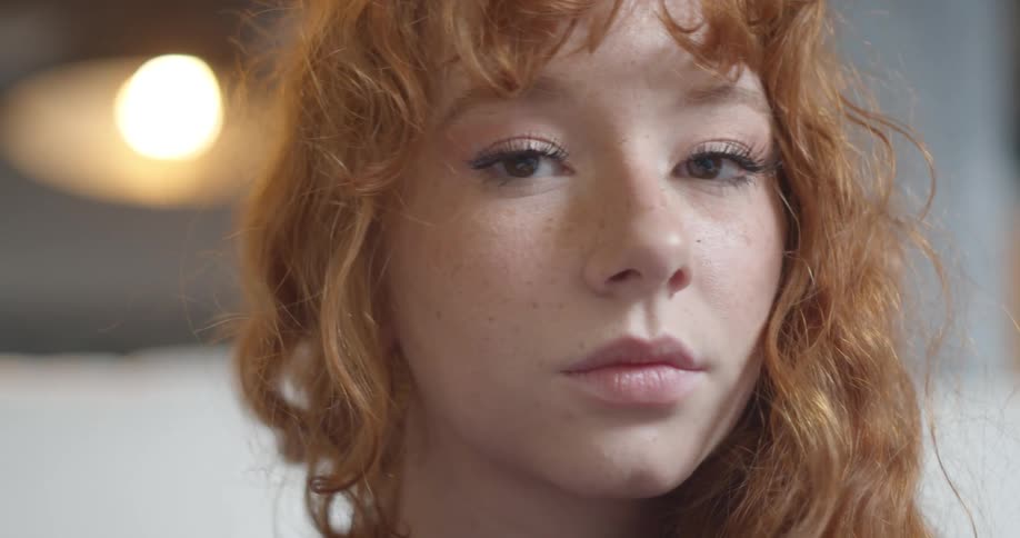 Redhead freckled girl turns to look at the camera