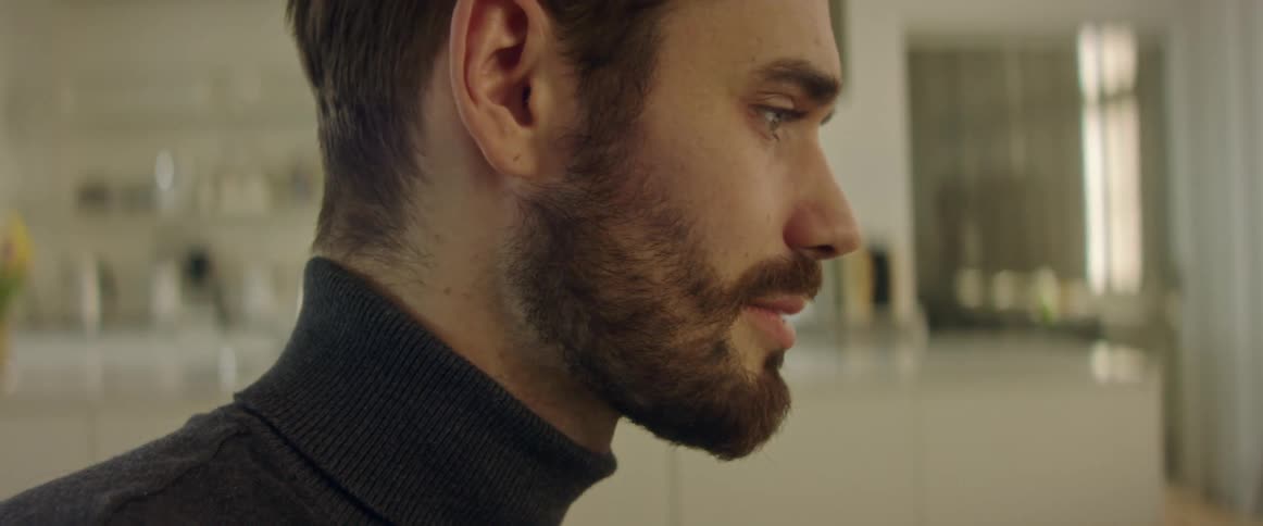 A man is standing inside his house and talking