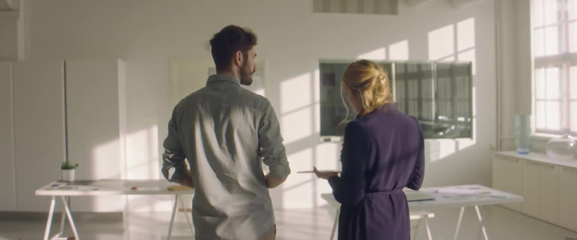 Coworkers walk into the office meeting room talking to each other