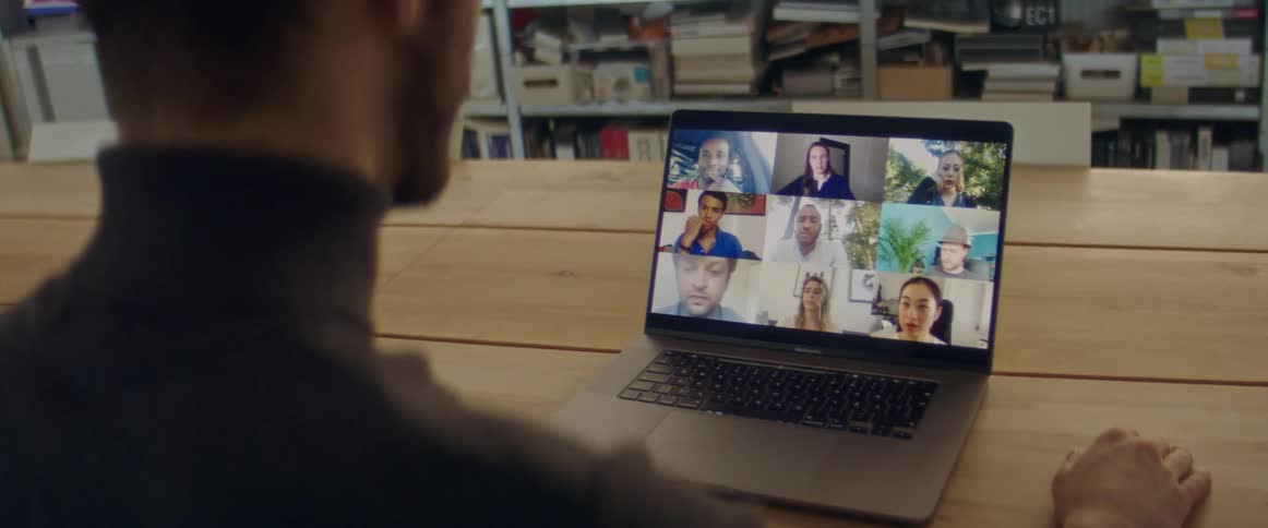 Man has a video chat with nine people on a laptop