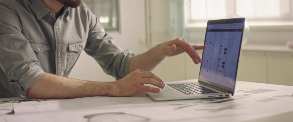 A man is talking and using a laptop