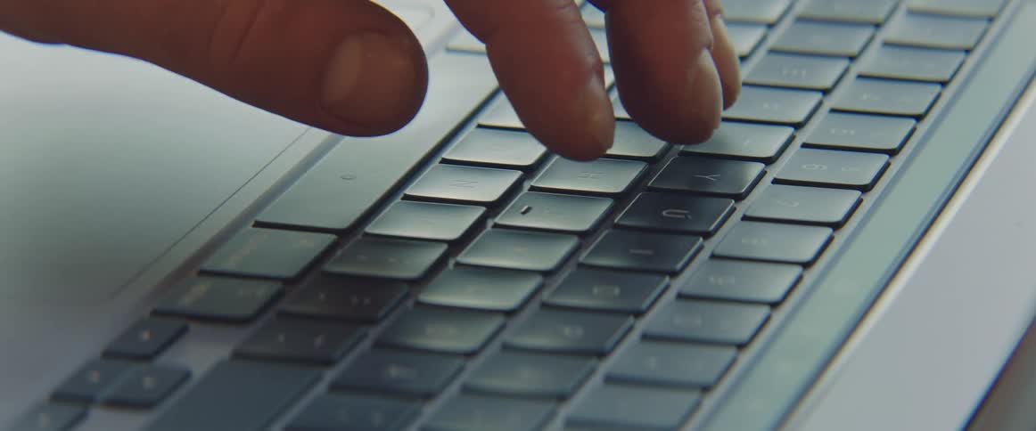 Fingers are typing on a laptop computer keyboard