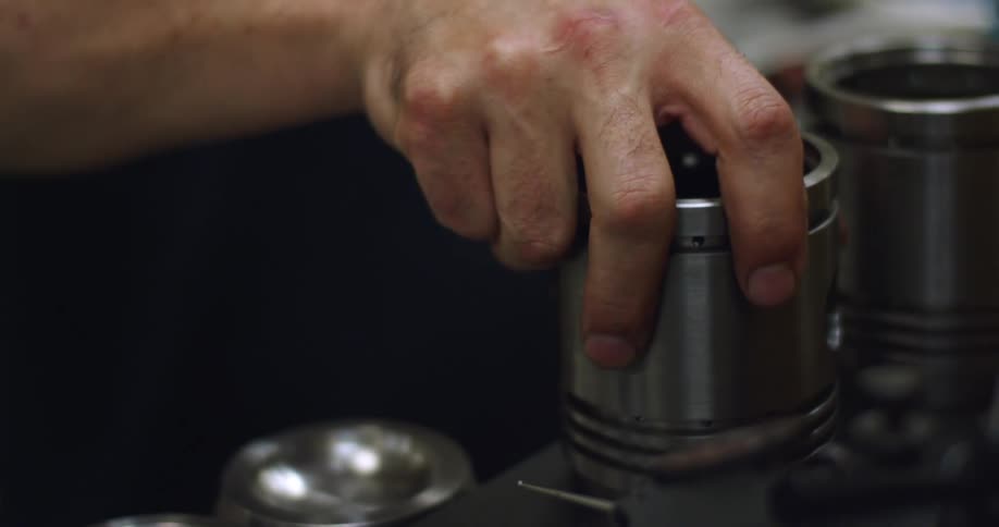 A person in a room wiping a cylinder with a cloth