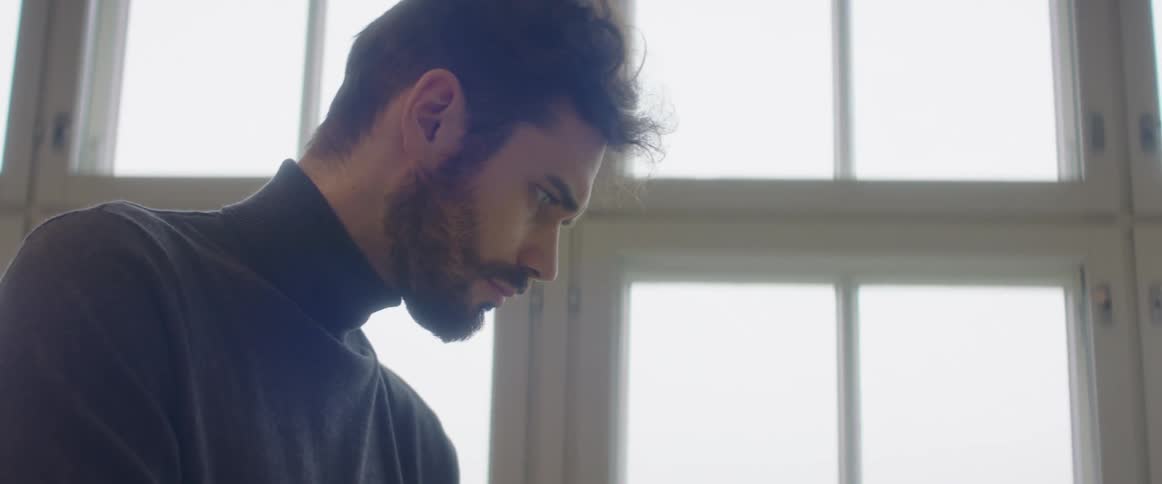A man in an office looks down and concentrates