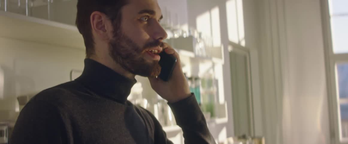 A man that is talking on a smart phone in a building