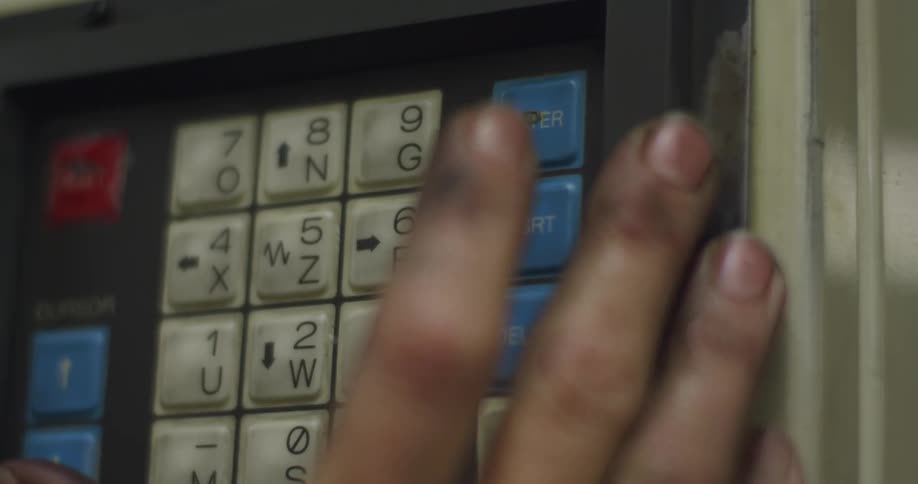 A man with dirty fingers pushes buttons on a machine