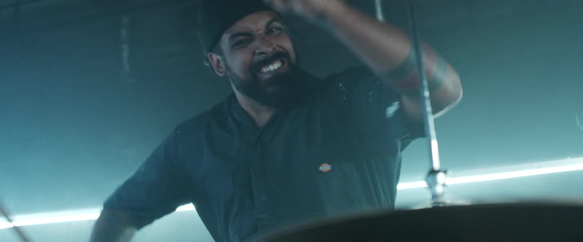 A man is playing drums in the smoke filled room