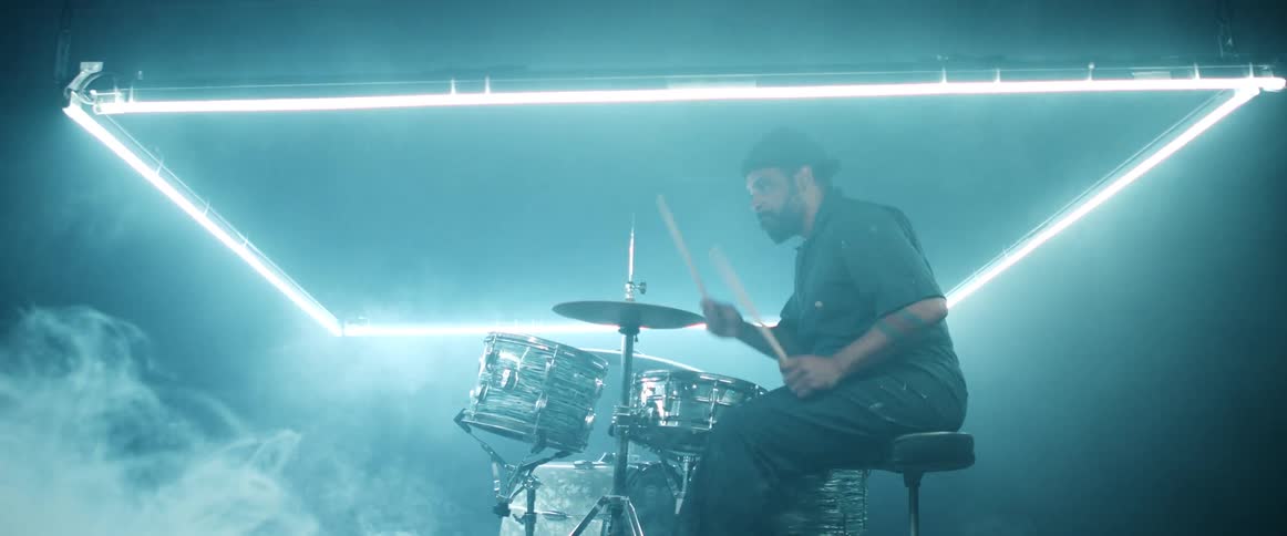 A man is playing the drums in a venue