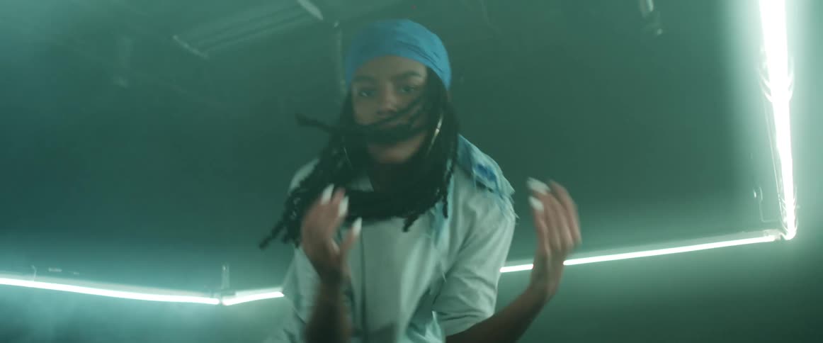 A woman is dancing in a room with lights