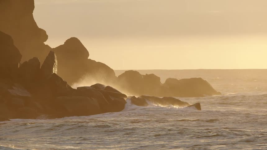 Multiple waves crash upon an incredibly rocky coastline