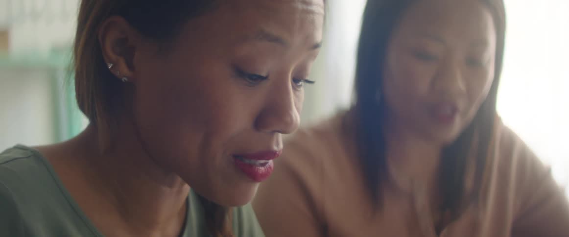 Two women talk inside