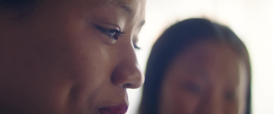 Side view of woman nodding and shedding tears of happiness