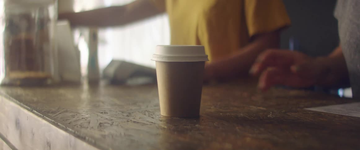 A person gets a coffee in a cafe during the day