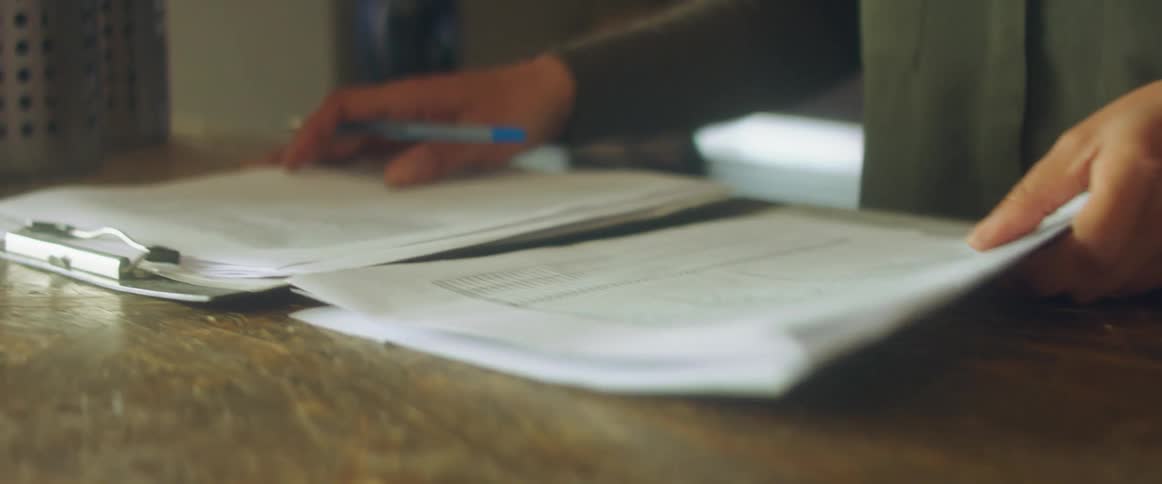 A person is looking at papers on a table indoors