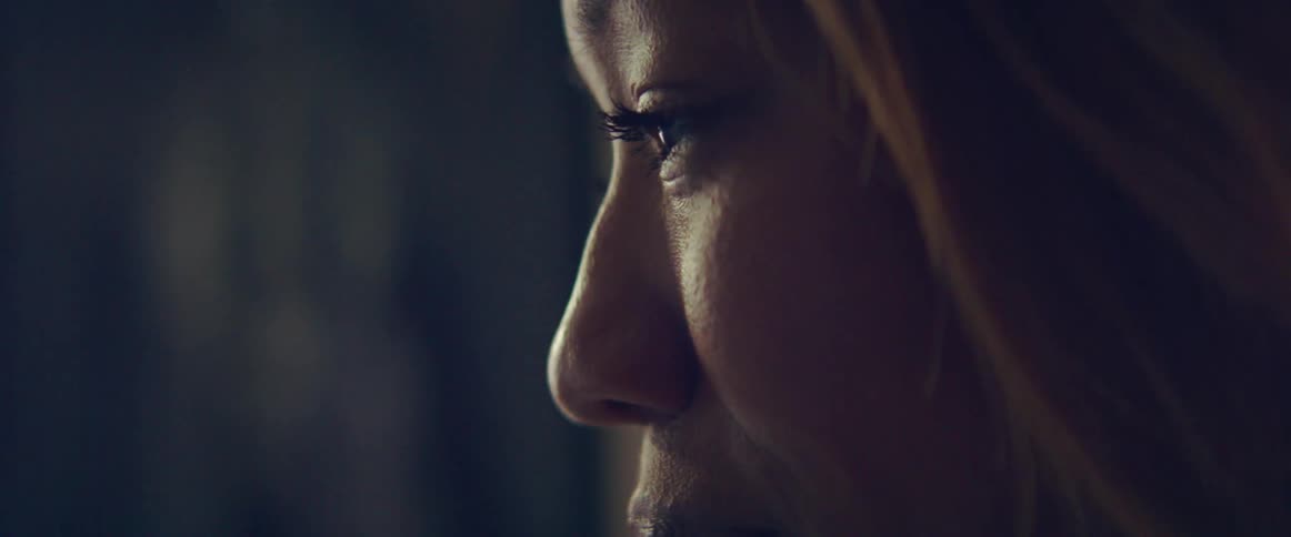 Close up of a womans face as she looks down and then ahead