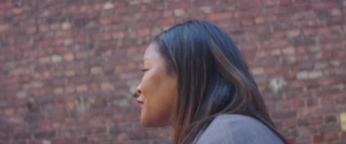 Women sit outdoors at table near building having an animated discussion