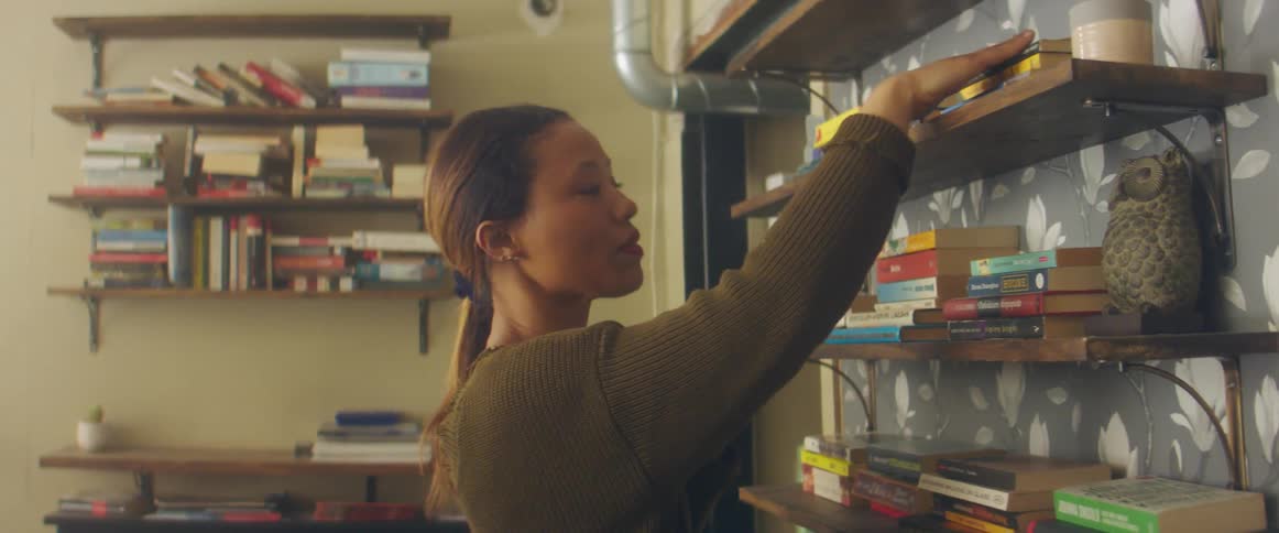 A woman organizes books on a store shelf