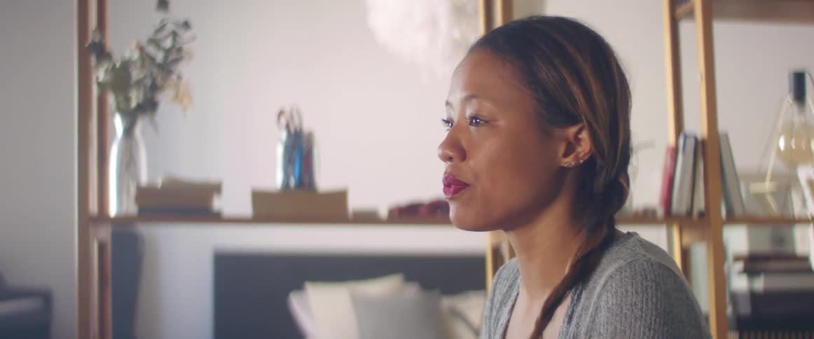 Woman carrying a laptop sits on the couch in the living room
