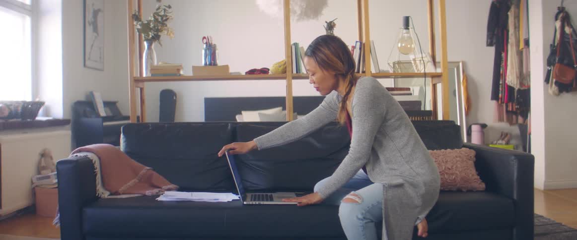 A woman sits down and opens her laptop