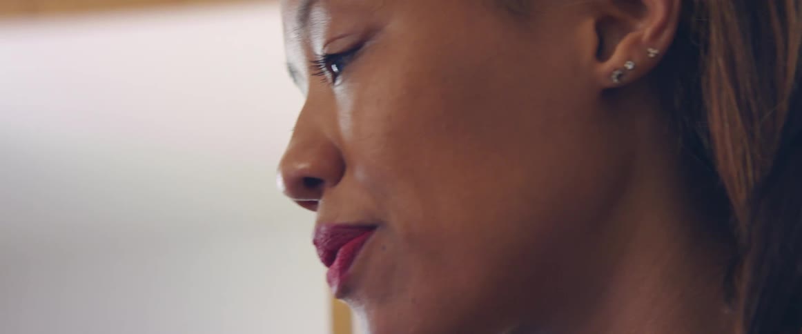 Close up of a womans face as she looks ahead and smiles