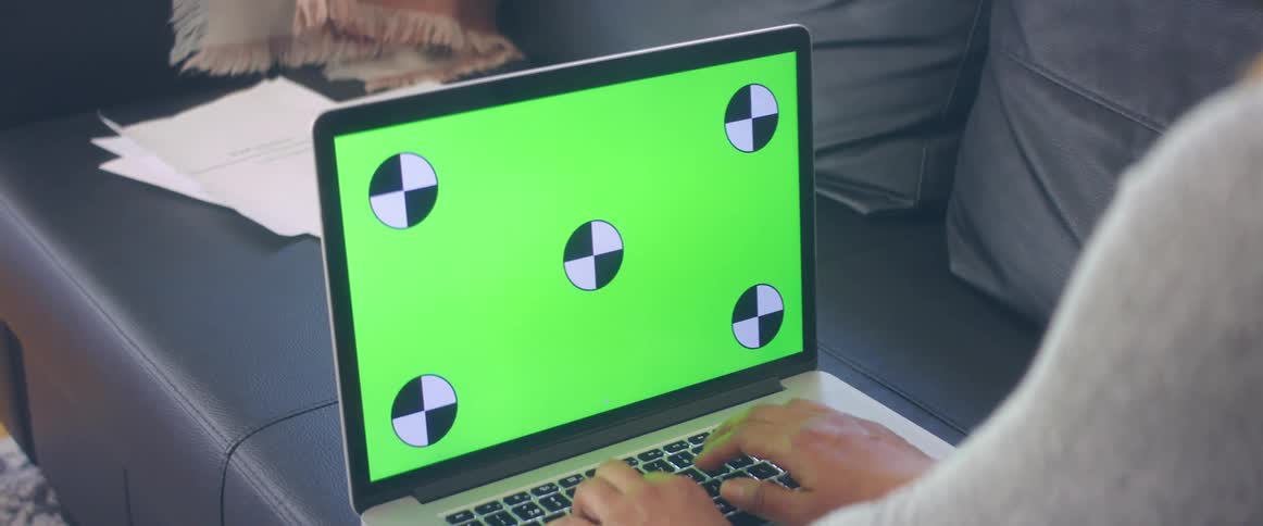 A woman is typing on a laptop and sitting on a couch