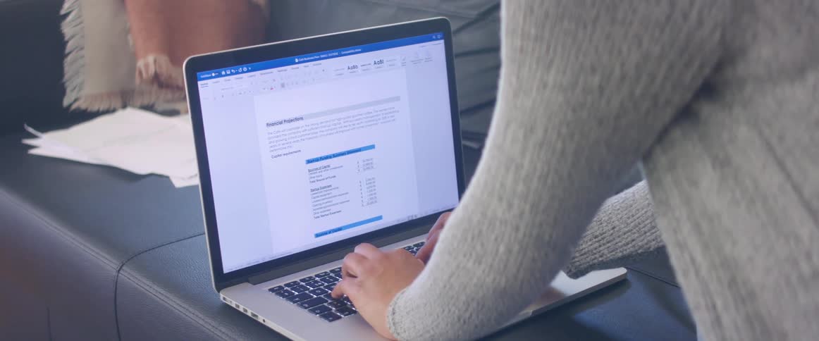 A woman is typing on a laptop