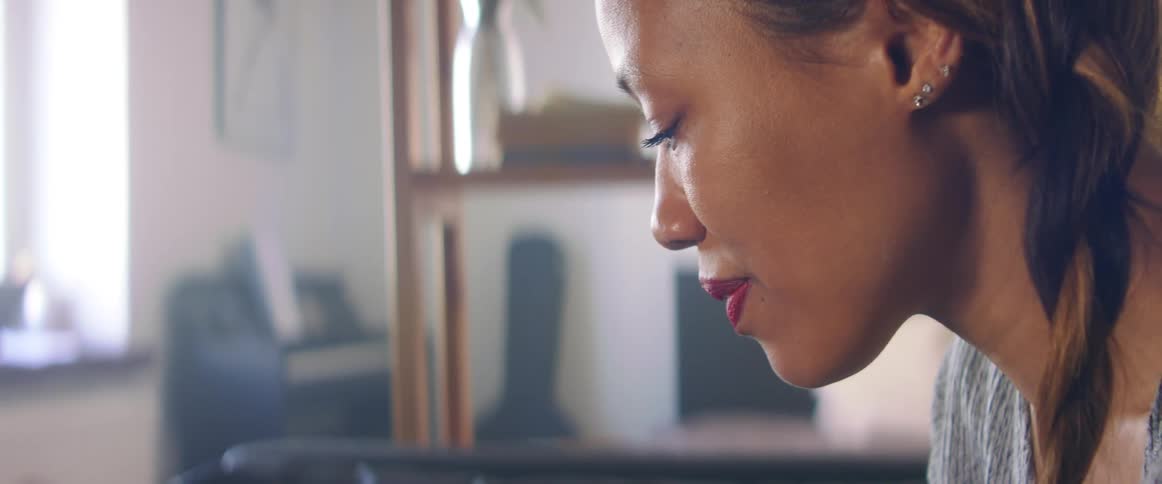 A woman is looking down and smiling