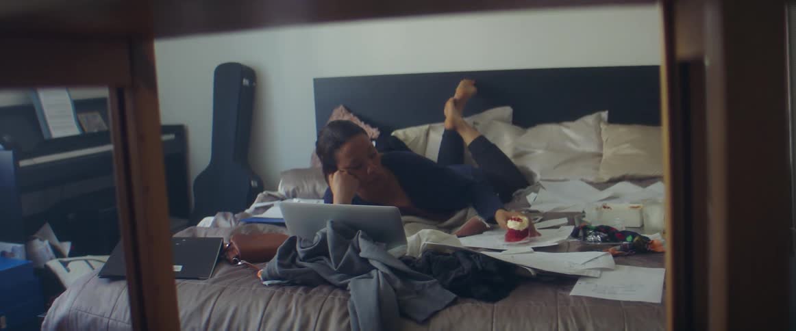 A woman laying bed on a computer