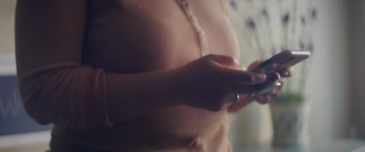 A woman is typing on her cell phone