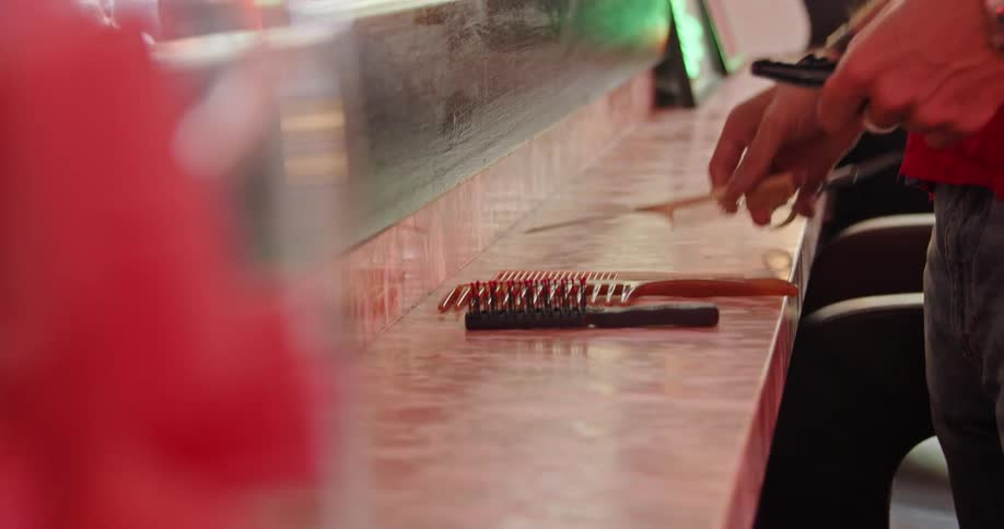 Stylist aligns combs on a shelf in the salon