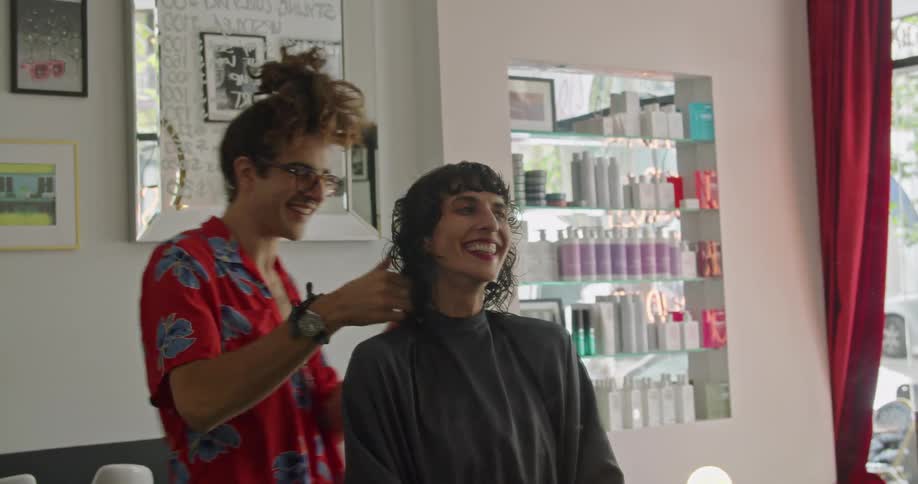 A man cutting a womans hair in a salon