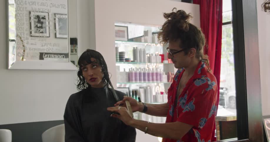 Hair stylist cuts womans hair while she talks