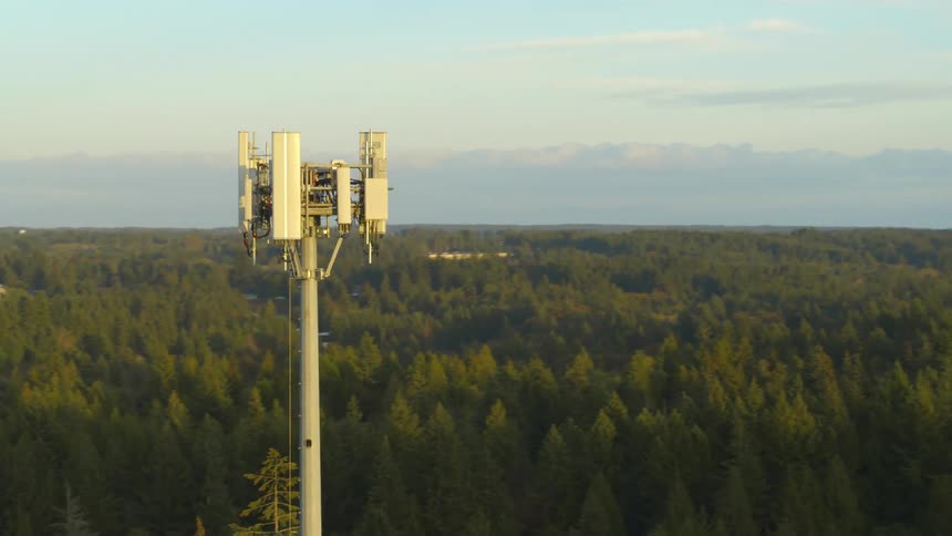 A 5G cell tower located within a forest and near suburban communities