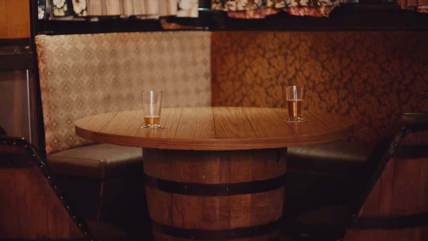 Glasses of beer resting on a table inside a rustic pub or tabern