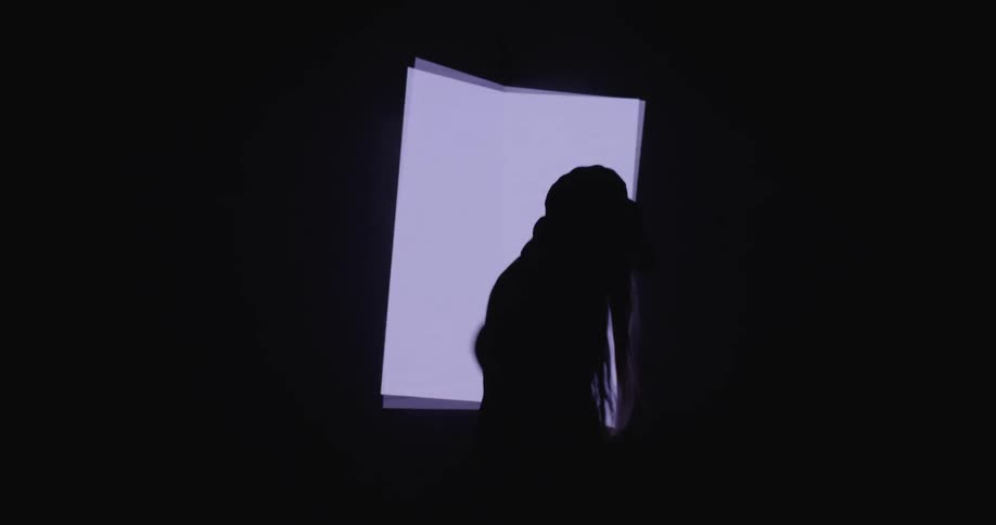 A woman dancing around in front of a cube
