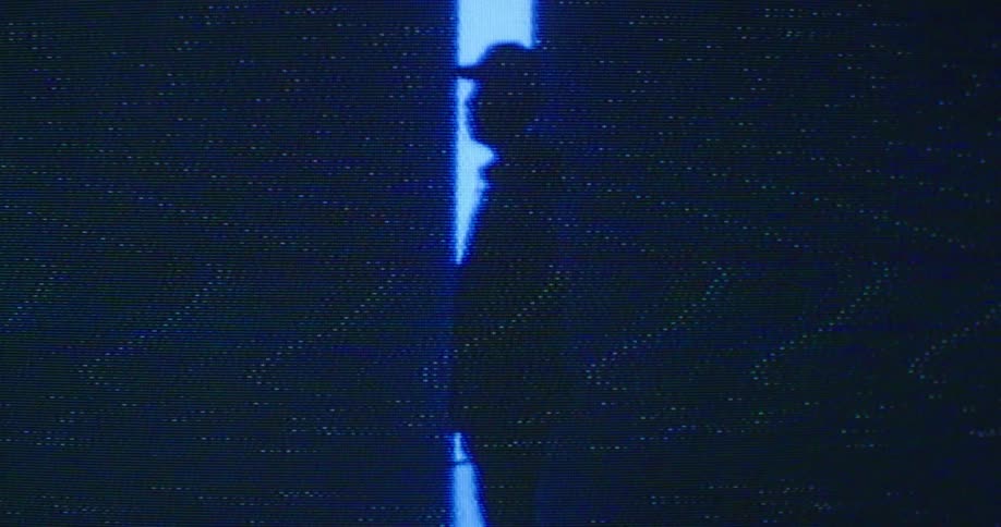 A man standing in a room full of screens
