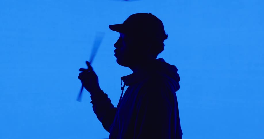 A man is wearing a hat and moving an object in his hand