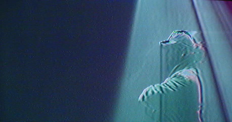 A man with a hat and jacket in a room with laser lights in the background