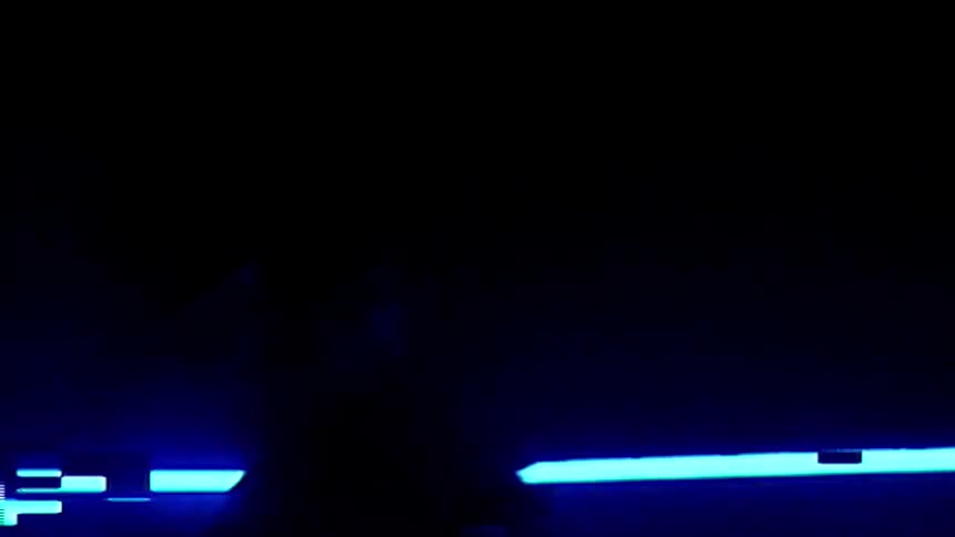 A man spins his drum sticks in the dark room