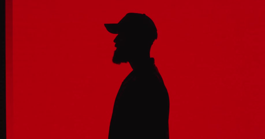 A man is wearing a hat and standing indoors