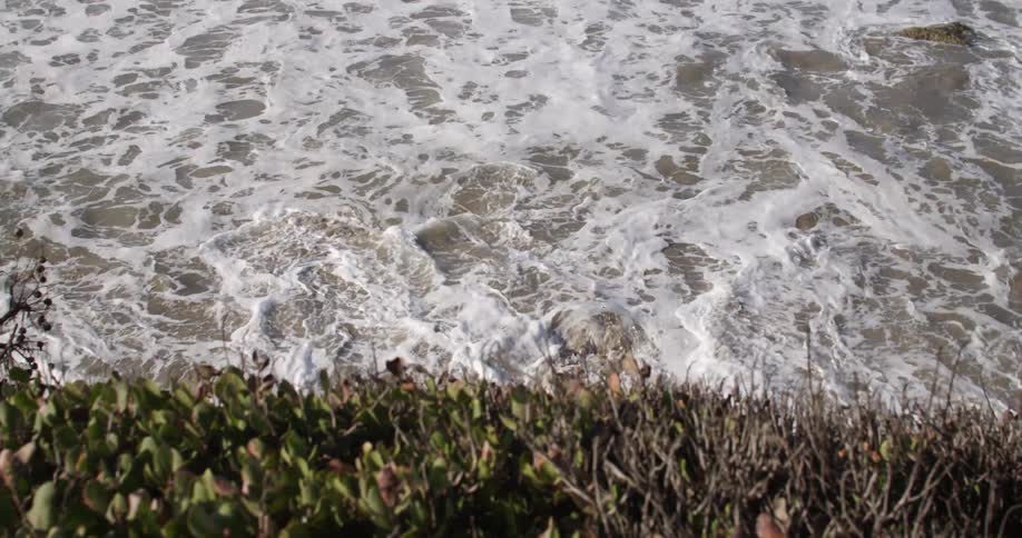 White foaming water rolls up to the shoreline