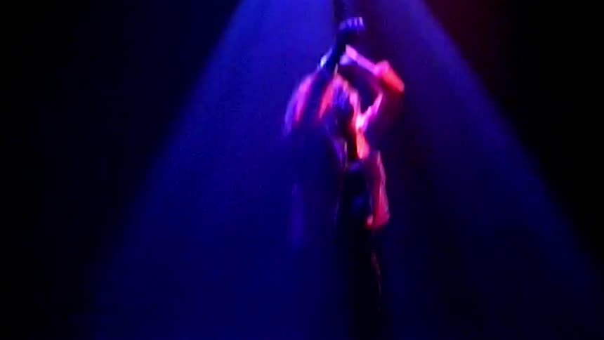 A woman dancing on stage beneath flashing lights