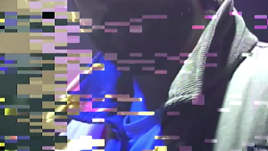 Digital effects occur to image of man standing in nightclub with bright changing lights