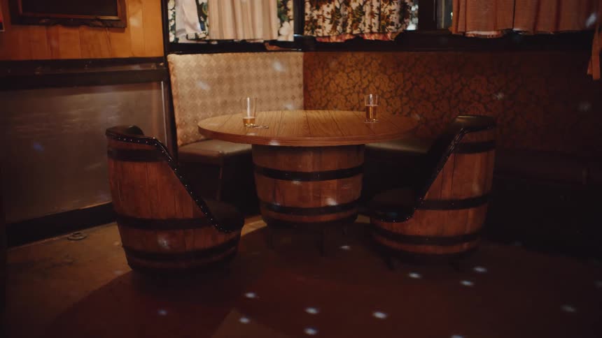 Two beer glasses on wood round table in the corner in a bar