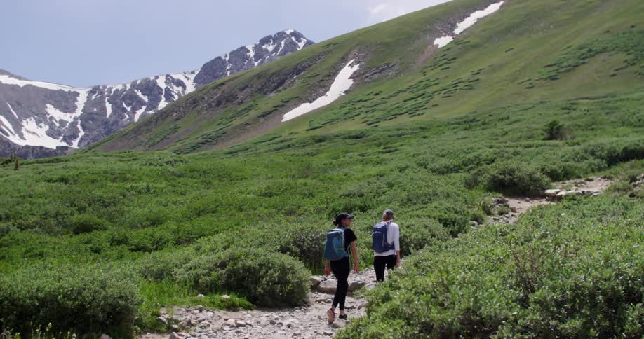 Two hikers ascending a rocky trail