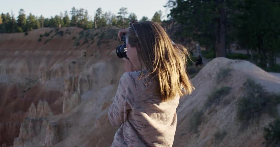 Woman taking photographs of a canyon