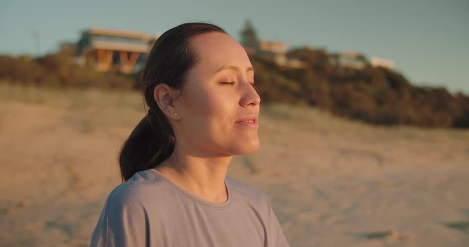 A woman is resting as she stands on the beach
